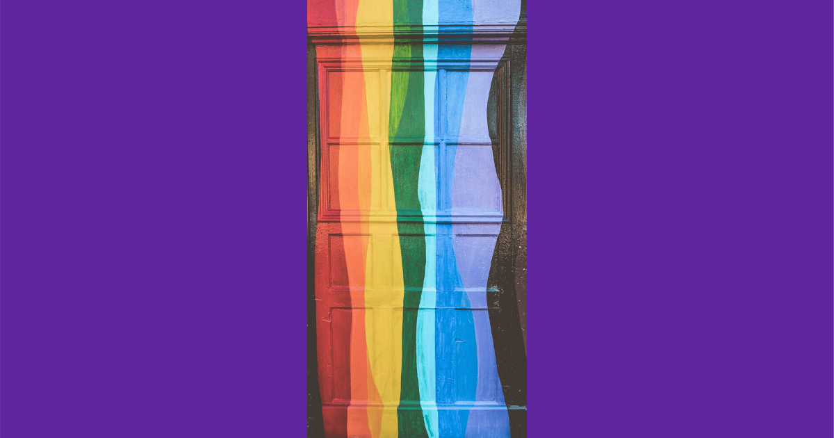 A photo of a doorway painted with a wavy vertical rainbow flag. The photo is on a purple background.