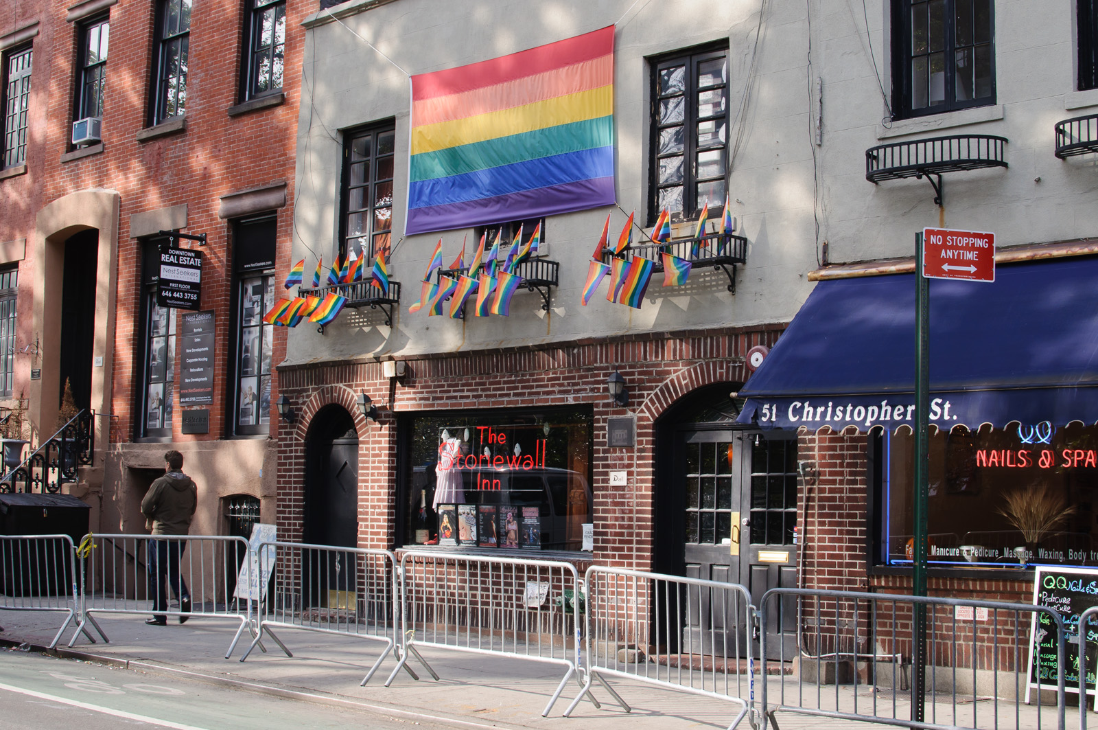 A picture of the exterior of the Stonewall Inn with a large rainbow flag hanging above the entrance