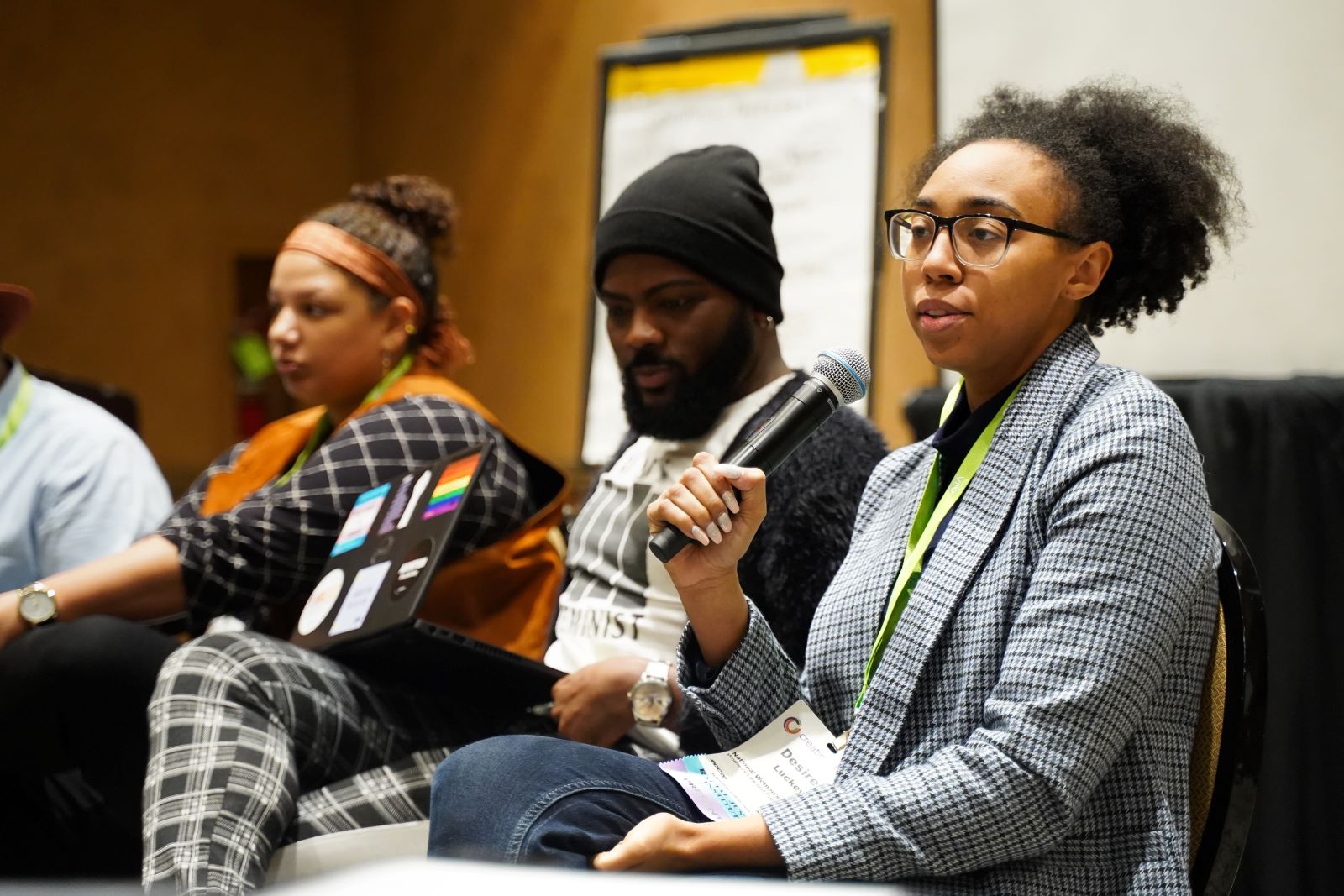 Black panelist speaks into a microphone during a Creating Change breakout session