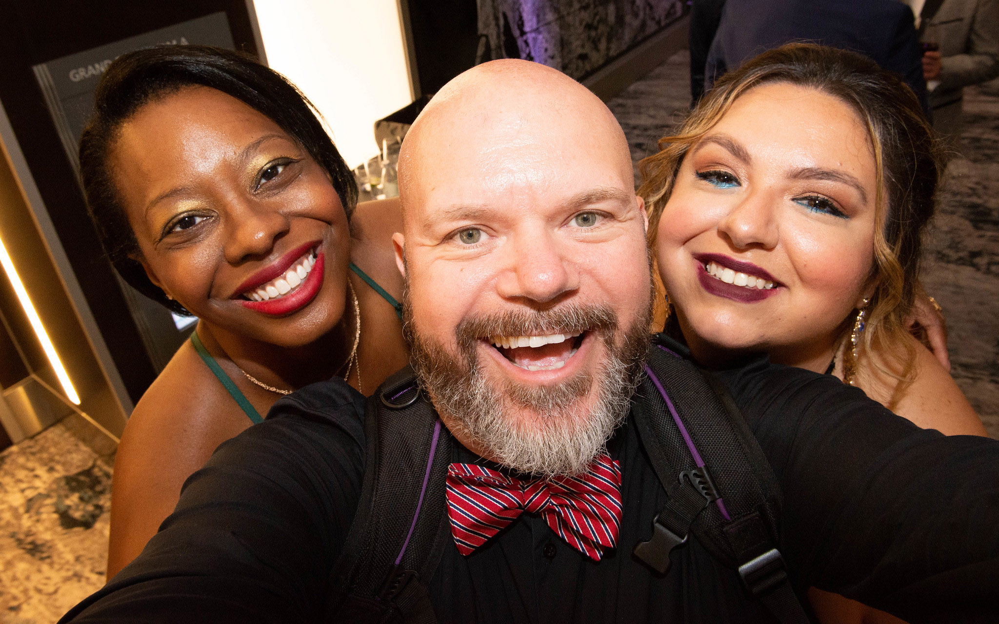 Three people smiling into the camera.