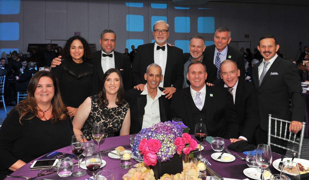 Eleven people - the Task Force Gala Table Captains - standing around a table at the Gala.